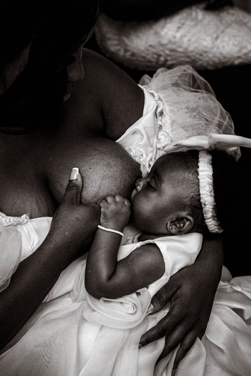 A calm, content breastfed baby resting after a feed in a parent's arms